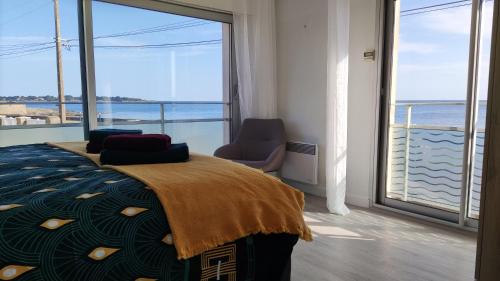 孔卡爾諾的住宿－Appartement T3 de 74m2 très lumineux vue panoramique mer et plages，一间卧室设有一张床,享有海景