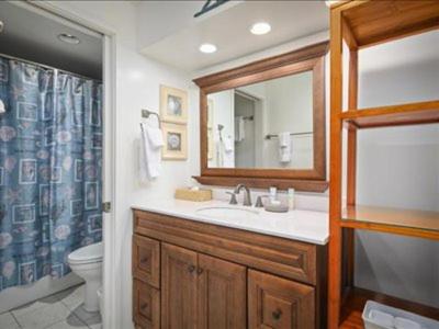 a bathroom with a sink and a toilet and a mirror at Royal Sea Cliff Kona by OUTRIGGER in Kailua-Kona