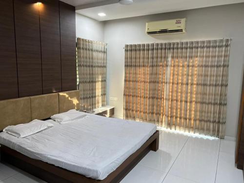 1 dormitorio con cama y ventana grande en ASMA en Ahmedabad