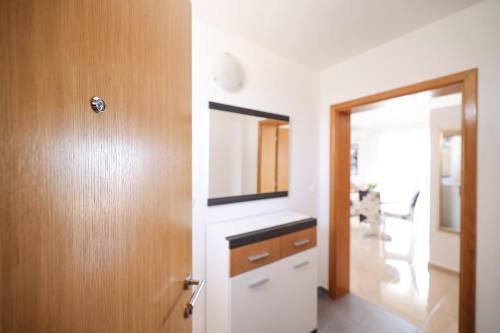 a bathroom with a sink and a mirror next to a door at Chill 4 Real Sea View Mandre in Mandre