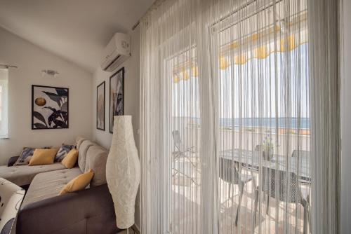 uma sala de estar com um sofá e uma grande janela em Chill 4 Real Sea View Mandre em Mandre