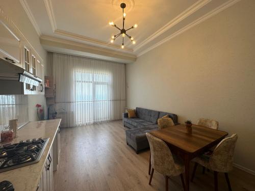 Caspian Pearl Residence في سومقاييت: مطبخ وغرفة معيشة مع طاولة وأريكة
