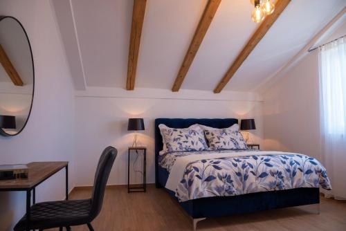 a bedroom with a bed and a desk and a chair at Apartmani Lavanda in Bibinje