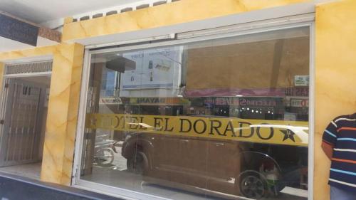 a store window with a reflection of a car in it at EL Dorado Hotel Maicao in Maicao