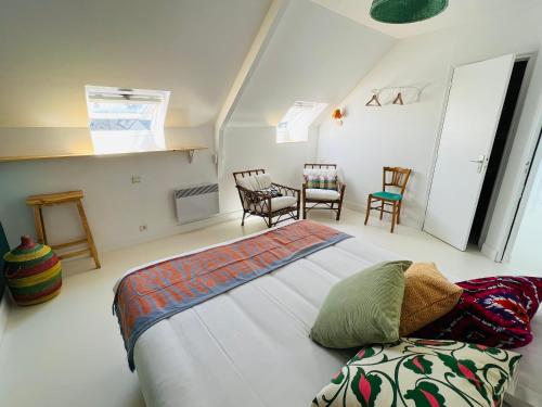 a bedroom with a bed and a table and chairs at Coco bay in Saint-Benoît-des-Ondes