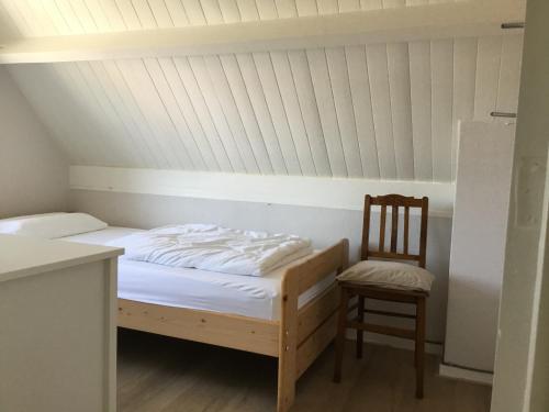 1 cama y 1 silla en una habitación en Kustverhuur, Hoofdplaat, Achterweg 10, en Hoofdplaat