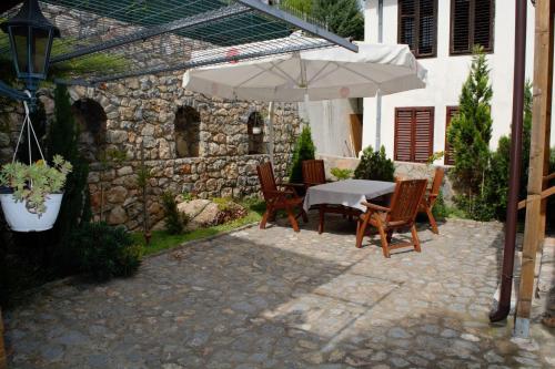 Villa Scandik Ohrid في أوخريد: طاولة وكراسي تحت مظلة على الفناء