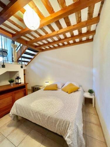 une chambre avec un lit et un plafond en bois dans l'établissement Appartement de charme en Drôme Provencale, à Montboucher-sur-Jabron