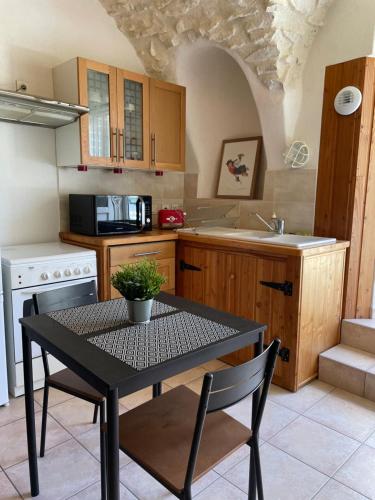 une cuisine avec une table et des chaises dans une pièce dans l'établissement Appartement de charme en Drôme Provencale, à Montboucher-sur-Jabron