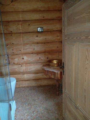 malinowy beret في Zatwarnica: حمام مع حوض في جدار خشبي