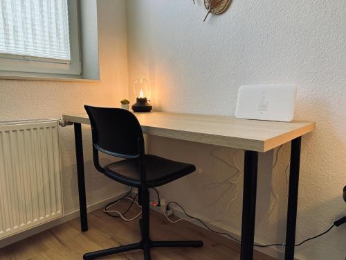 a desk with a chair and a laptop on it at FeWo Am Ring Neubau & Terrasse in Nordhorn