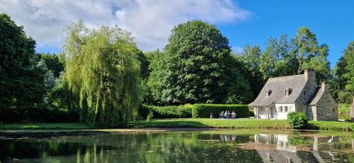a house and a pond in front of a house at La Grange du Moulin de Lossulien in Le Relecq-Kerhuon