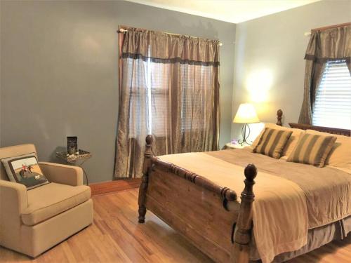 a bedroom with a bed and a chair and a window at Home near Zoo/College World Series/Downtown in Omaha