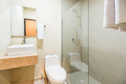 y baño con aseo, lavabo y ducha. en Ribai Hotels - Barranquilla, en Barranquilla