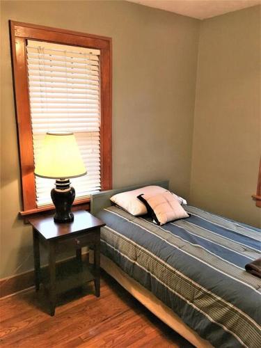a bedroom with a bed with a lamp on a table at Home near Zoo/College World Series/Downtown in Omaha