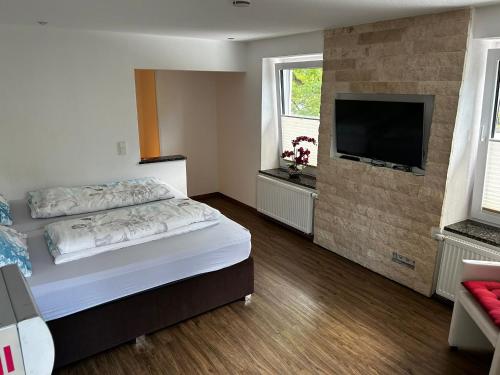 a bedroom with a bed and a flat screen tv at Alte Schmiede - XXL Foodhouse in Kempten