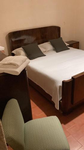 1 dormitorio con 1 cama grande con silla en Casale Bastida, en Bevagna
