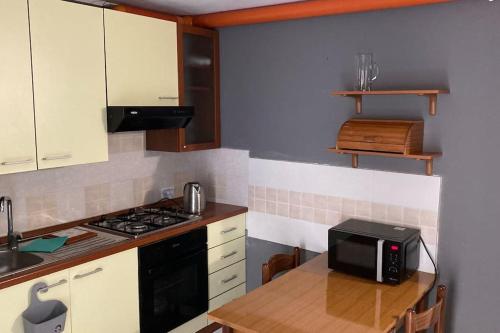 uma cozinha com um fogão e uma mesa com um micro-ondas em Tenuta Balabaia, Townhouse. em Caccamo