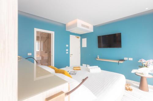 a blue room with a bed and a tv at Ambasciatori Suite Hotel in Sottomarina