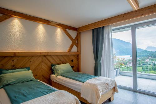 a bedroom with two beds and a large window at Dolomites Chalet Wolf in Molveno