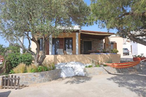 une maison avec un hamac en face de celle-ci dans l'établissement Pine Cottage, Syros Island, à Firókambos