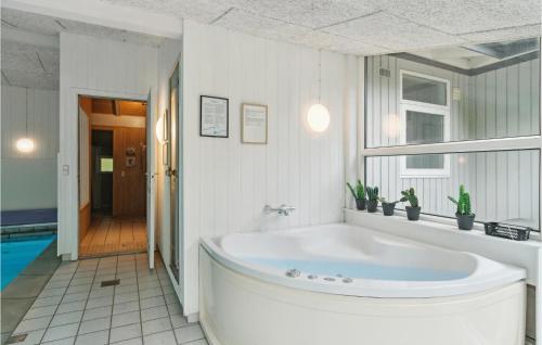 FjellerupにあるAwesome Home In Glesborg With Wifiの白い大きなバスルーム(バスタブ、窓付)