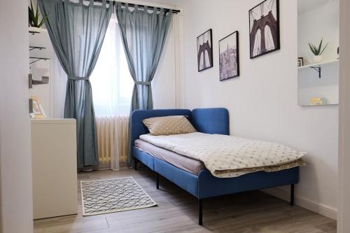 - un lit bleu dans une chambre avec fenêtre dans l'établissement Joy City Stay Versului 8, à Timişoara
