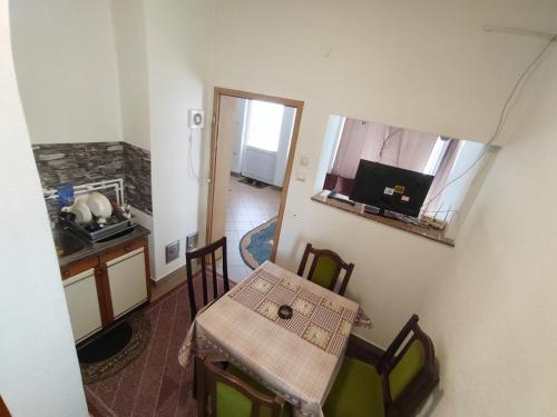 a small table and chairs in a room with a kitchen at Apartman HAX in Sjenica
