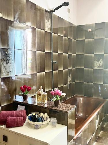 a bathroom with a tub and flowers on a counter at Home and Relax ROOMS in Furnari