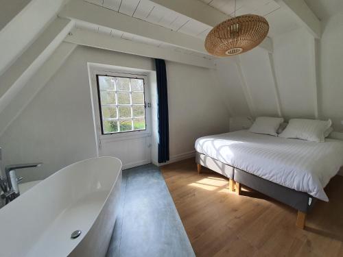 - une chambre avec un lit et une baignoire dans l'établissement La Grange du Moulin de Lossulien, à Le Relecq-Kerhuon