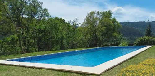 einen Pool in einem Garten mit Bäumen in der Unterkunft Casa do Cadaval in Rio Caldo