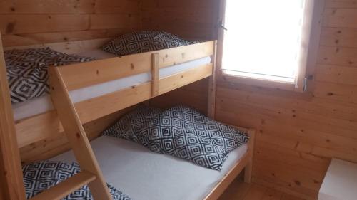 two bunk beds in a cabin with a window at Domki u Basi in Gąski
