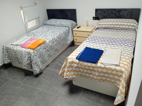 dwa łóżka ustawione obok siebie w pokoju w obiekcie Casa San Miguel 93 santander w mieście Santander