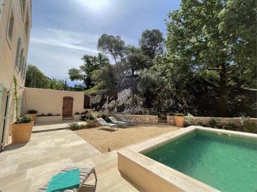 une piscine dans une cour à côté d'une maison dans l'établissement LES ROCHES, à Apt