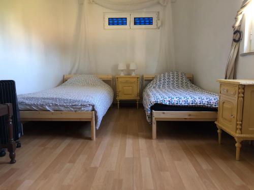 HERDADE PALMA t2 في Moita: سريرين في غرفة ذات أرضيات خشبية