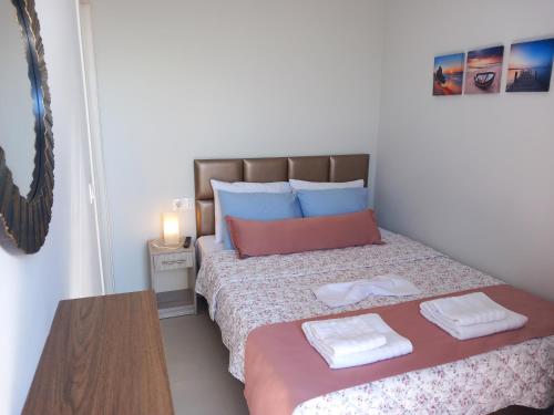 a bedroom with a bed with two towels on it at Bella Luxury Suite in Paralia Katerinis
