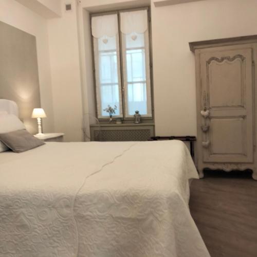 a bedroom with a white bed and a window at Al San Lorenzo in Bergamo