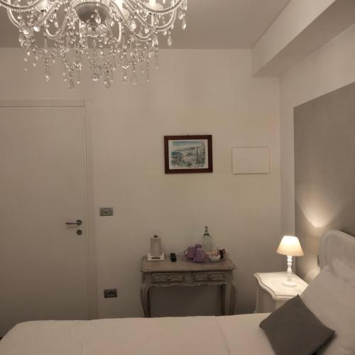 a bedroom with a bed and a chandelier at Al San Lorenzo in Bergamo