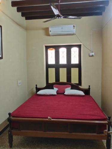 ポンディシェリにあるElite Heritage Stayのベッドルーム1室(赤毛布付きの大型ベッド1台付)