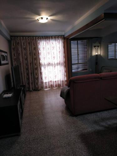 a living room with a couch and a window at Apartamento Siboney in Cullera