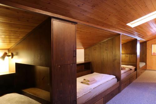 a bedroom with two beds in a wooden room at Chesa Dominium in Bergün