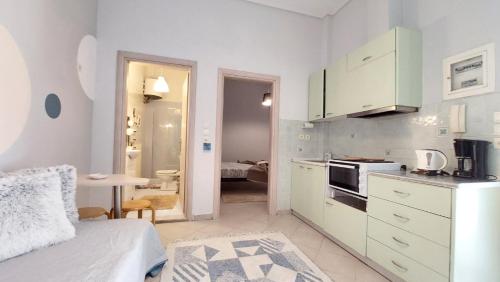 een witte keuken met een bed en een tafel in een kamer bij cozy minimal apartment in Piraeus