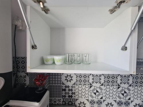 a kitchen with a white shelf with glasses on it at Spacious&modern 4 rooms apartment in Târgu-Mureş