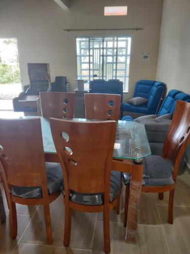 a dining room with a glass table and chairs at Finca Campestre El Pindal in Guamal
