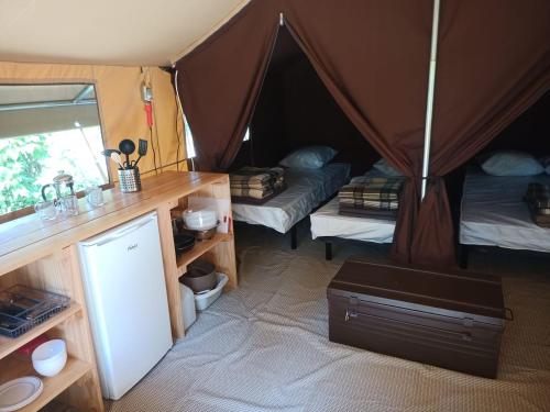 a room with two beds in a tent at Onlycamp Camping le Champ d'été in Reyssouze