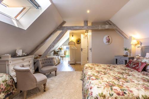 a attic bedroom with a bed and a window at Le Clos des Roses Chambres d hôtes aux portes de Beauval et des châteaux de la Loire in Meusnes