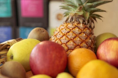 a basket of fruit with a pineapple and apples at Hotel Bains Sarrailh in Dax
