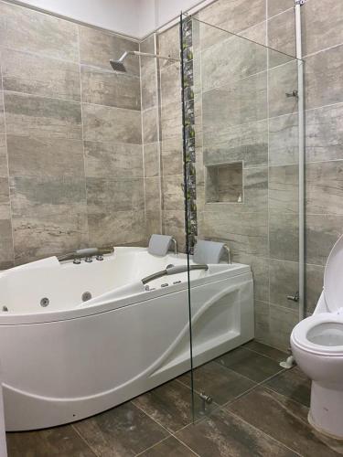 a bathroom with a white tub and a toilet at APARTAMENTO DORADAL in Doradal