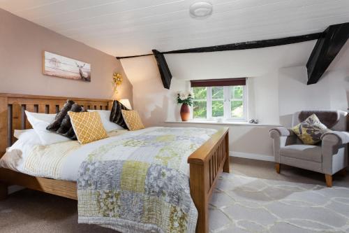 a bedroom with a large bed and a chair at The Snuggery a Cosy Country Cottage in Wellington