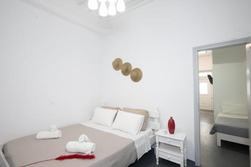 um quarto branco com uma cama com toalhas em MATEOS APARTMENT WINDMILLS TOWN em Míconos